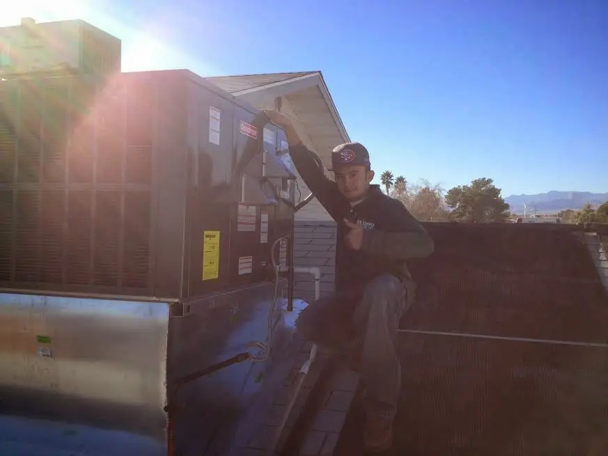 HVAC technician performing Boiler Repair on a rooftop unit in Marshall